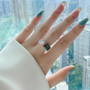 Close-up of S925 silver open ring with teardrop clear stone and emerald-cut green gem