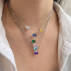 Primo piano di collane in argento S925 con cristalli colorati taglio smeraldo sul modello