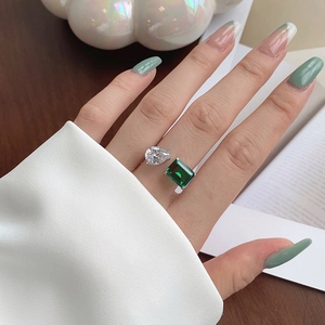 Detail of S925 silver ring featuring pear-cut and emerald-cut stones on a finger