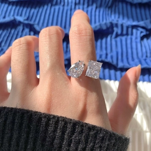 Gros plan d'une bague en argent S925 avec diamants de synthèse poire et émeraude au doigt