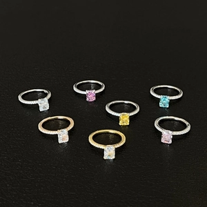 Detailed view of colorful rectangular radiant cut rings on black leather background