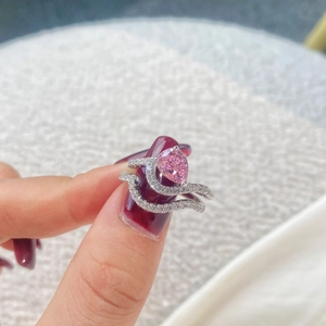 Detalle macro del juego de anillos de plata con piedra rosa pera y pavé denso