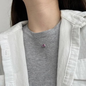 Dettaglio macro della collana con pendente in zaffiro rosa dal taglio quadrato