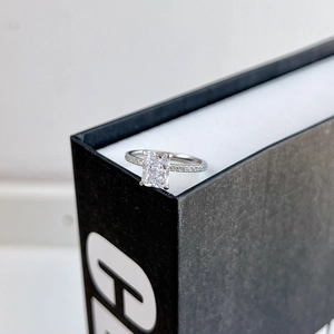 Macro detail of rectangle cut zircon ring with micro-paved band on black background