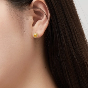 Detailopname van gele vierkante edelsteen oorbel met een sprankelende diamanten halo