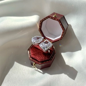 Détail macro de cristaux taille poire et émeraude sur bague argentée en écrin rouge