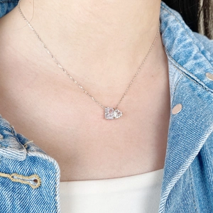 Close-up of S925 silver necklace with heart and radiant cut carbon diamond pendants