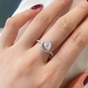 Detalle del anillo de plata S925 con circonita talla pera y diseño de banda cruzada