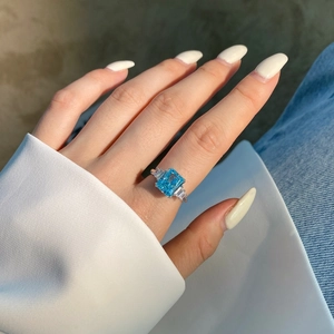 Radiant geslepen lichtblauwe edelsteen ring op hand met s925 zilver en luxe zirkonia
