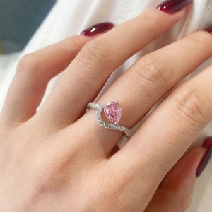 Detalle de anillo con circonita rosa talla pera y banda pavé con diseño en S