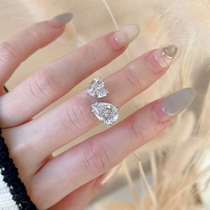 Detalle del anillo de plata S925 con piedras de corazón y pera en la mano de una modelo