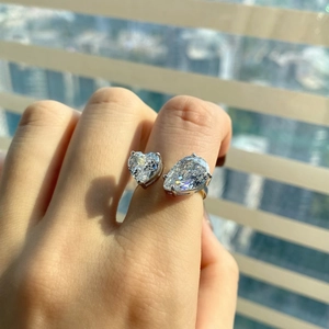 Primer plano de anillo de plata S925 con piedras de corazón y gota en la mano
