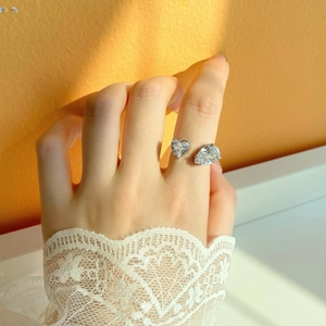 Detalle del anillo de plata S925 con piedras talla corazón y pera sobre una modelo