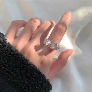 Detalle de anillo de plata S925 con piedras de talla corazón y pera puesto en la mano