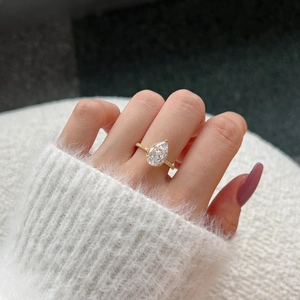 Vue détaillée d'une bague goutte d'eau en or 18 carats sertie de diamants sur main