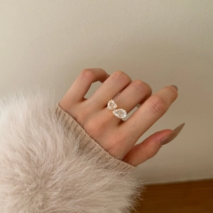 Detalle de anillo de plata S925 con circonitas en forma de corazón y pera dorada