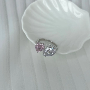 Detail of S925 silver ring featuring pink heart and pear cut stones in a shell tray