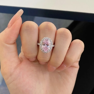 Gros plan d'une bague en argent 925 avec pierre rose ovale et entourage de zircons