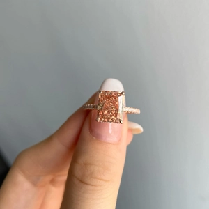Detailed close-up of a large radiant cut champagne gemstone ring in rose gold setting
