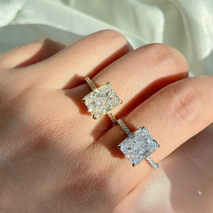 Macro detail of rectangle-cut zircon rings in gold and silver plating on silk