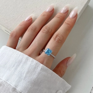 Detailed close-up of 8A square sky blue gemstone ring with micro-pave silver band