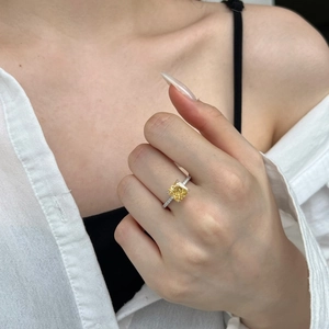 Dettaglio macro di anello con gemma gialla taglio quadrato e castone a quattro griffe