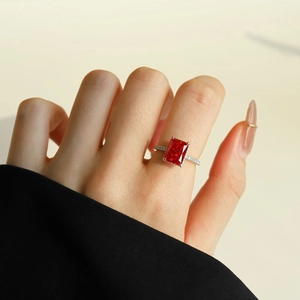 Macro detail of rectangle cut red ruby ring with sparkling side stones on silver band
