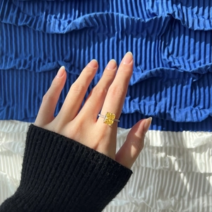 Close-up of radiant cut yellow gemstone ring on model with silver band and side stones