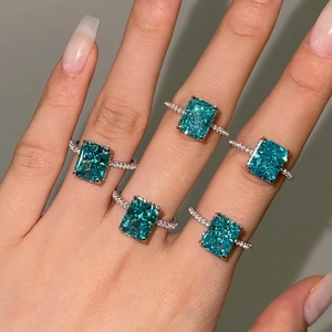 Detailed macro of 925 sterling silver rings with emerald cut blue-green cubic zirconia