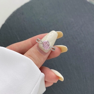Close-up of S925 sterling silver ring with oval pink zircon and pavé crisscross band