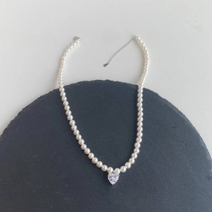 Detail of S925 sterling silver pearl necklace with sparkling heart-shaped zircon pendant