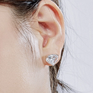Close-up of heart-shaped pink cubic zirconia stud earring on a female ear