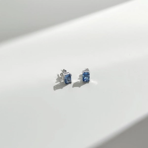 Macro detail of S925 sterling silver square earrings with deep blue radiant-cut gemstones