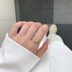 Primer plano de un anillo de lujo con circón amarillo radiante y halo de pavé diamante