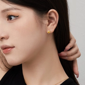 Détail macro de boucles d'oreilles carrées avec pierre jaune et coupe fleur de glace