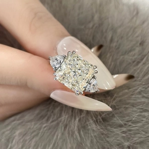 Macro shot of s925 silver radiant cut yellow gemstone ring on grey faux fur background
