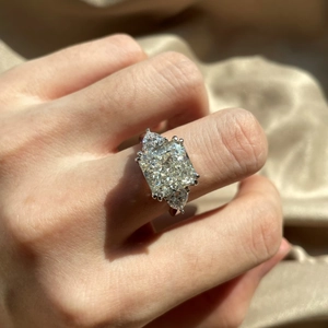 Macro detail of radiant cut high carbon diamond ring with pear side stones on hand