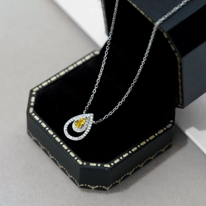 Vista detallada del collar con piedra amarilla en forma de gota en estuche de lujo