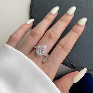 Macro de la bague halo en argent S925 avec zircon poire sur le doigt d'un mannequin
