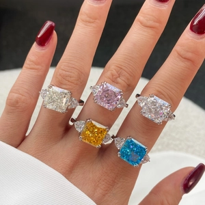Five radiant cut colorful high carbon diamond rings with side stones on hand