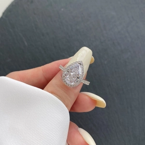 Bague halo en argent S925 avec pierre taille poire et pavé sur une main
