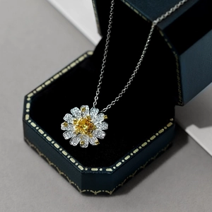 Macro shot of S925 silver daisy pendant with yellow zircon in a navy jewelry box