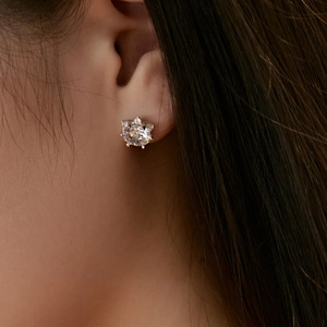 Nahaufnahme eines funkelnden S925 Sterlingsilber Kamelien-Zirkonia-Ohrrings am Ohr