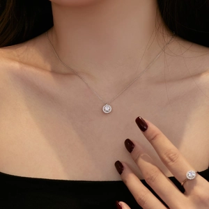 Gros plan sur un ensemble collier et bague halo en argent S925 avec pierres rondes brillantes