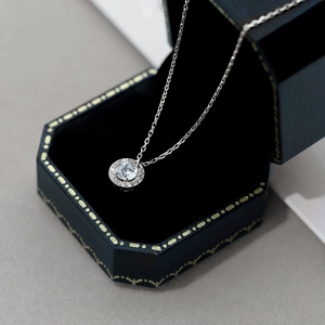 Détail d'un collier avec pendentif halo en argent sur un coffret à bijoux bleu