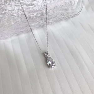 Détail du collier en argent S925 avec grand zircon goutte sur tissu plissé blanc