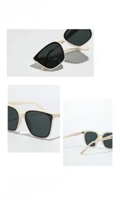 Close-up of beige square frame sunglasses with rivet details and dark lenses
