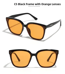 Detailed view of black frame sunglasses with orange lenses and metal rivet accents