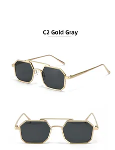 Detail view of gold metal double-bridge sunglasses with dark grey geometric lenses