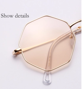 Close-up of geometric gold metal frame sunglasses with light brown tinted lenses